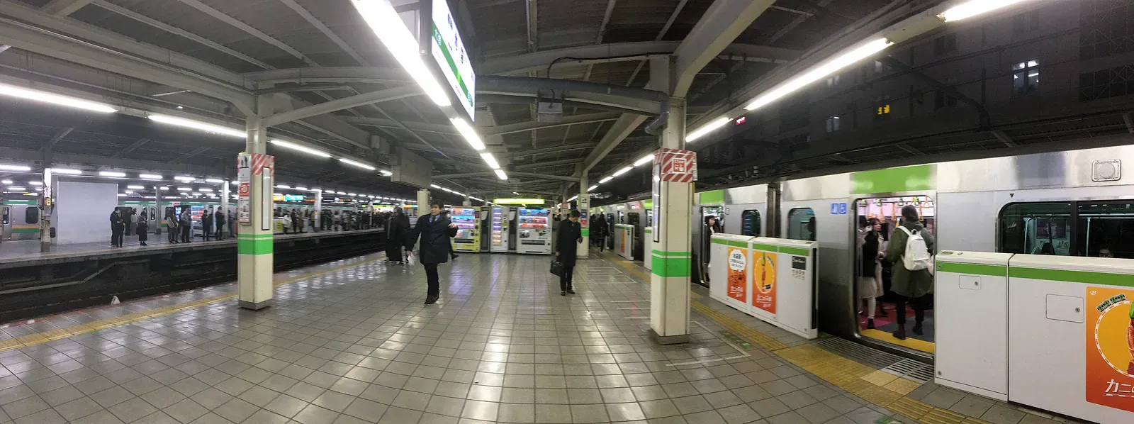 Commuter train waiting at a Tokyo station platform at night