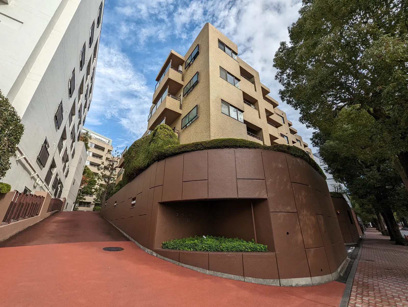 Beige apartment block behind a curved brown retaining wall