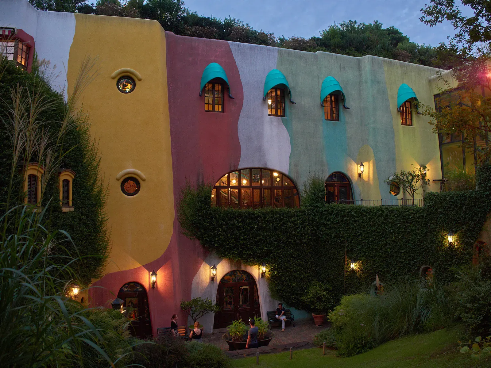 Colourful museum wall with arched windows and ivy at dusk